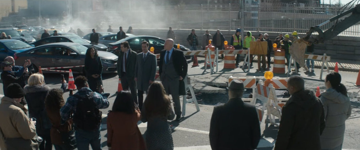 Fisk makes a quick public speech by the giant pothole.