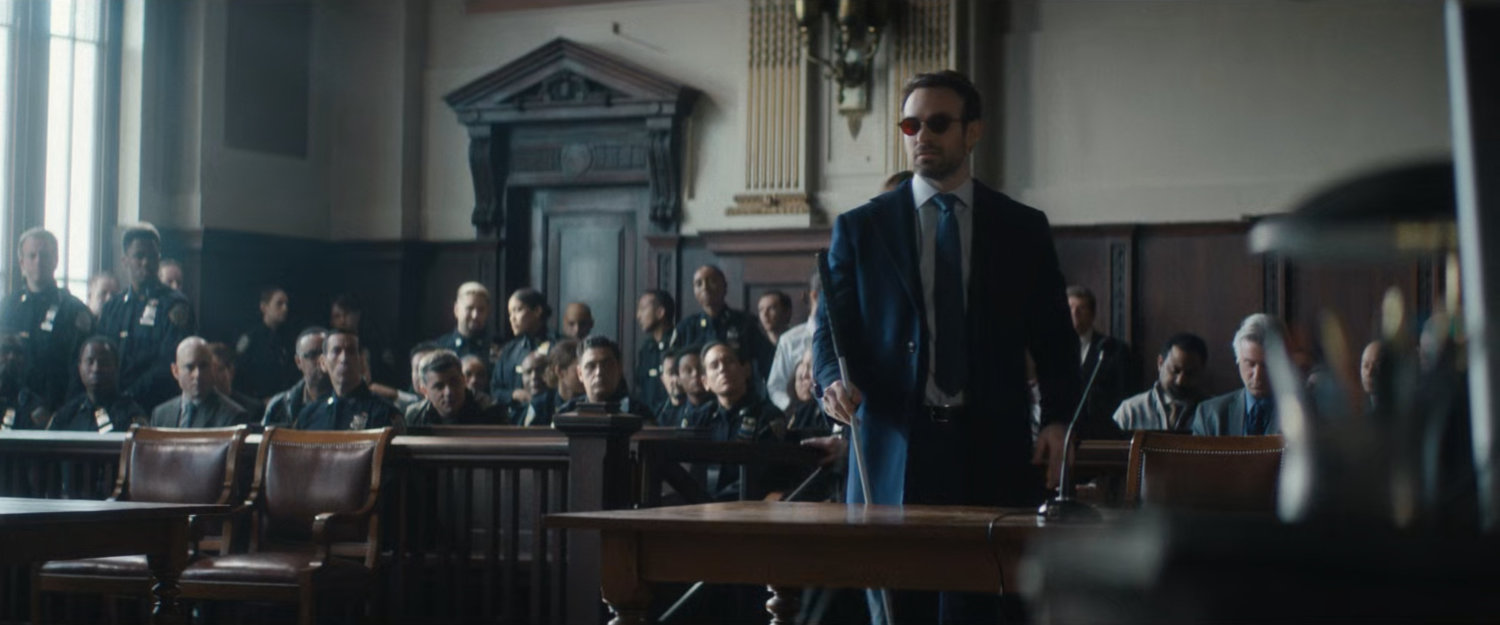 Matt in a courtroom, with dozens of police officers in the gallery.