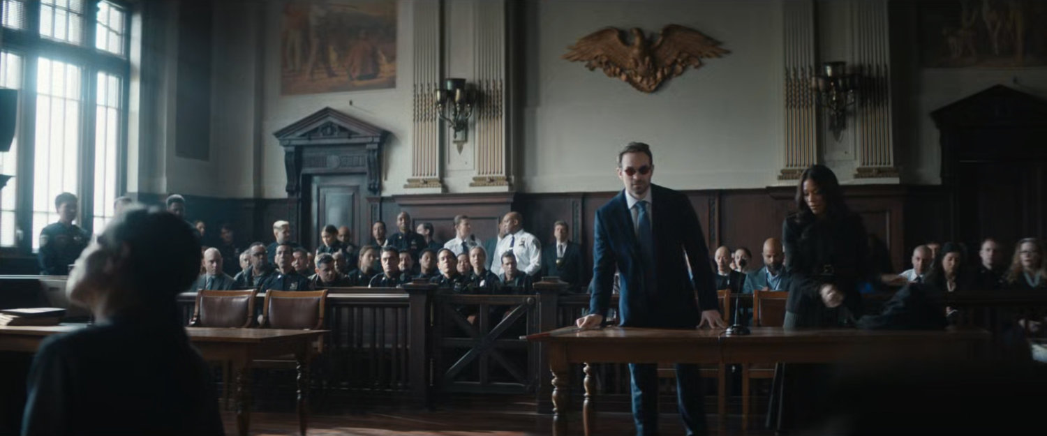 Matt and Kirsten in a courtroom with dozens of police officers.