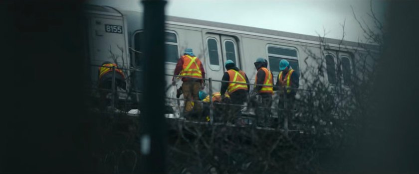 Interstitial: workers by elevated Metro train.