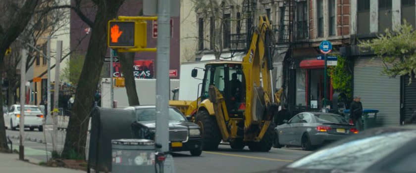 Interstitial: back hoe on city street.