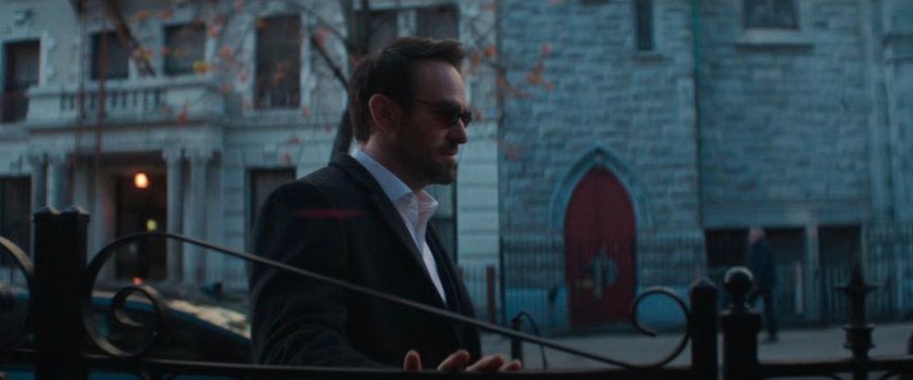 Matt standing across the street from a church with red doors.