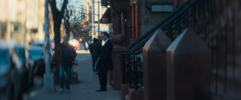 Matt leaning on a column on the sidewalk near the 15th Precinct.