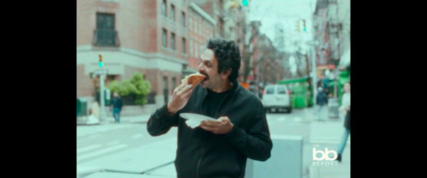 BB Report: man eating pizza on street corner.