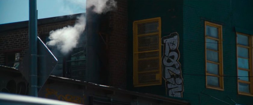 Interstitial: graffiti on the side of a green building.