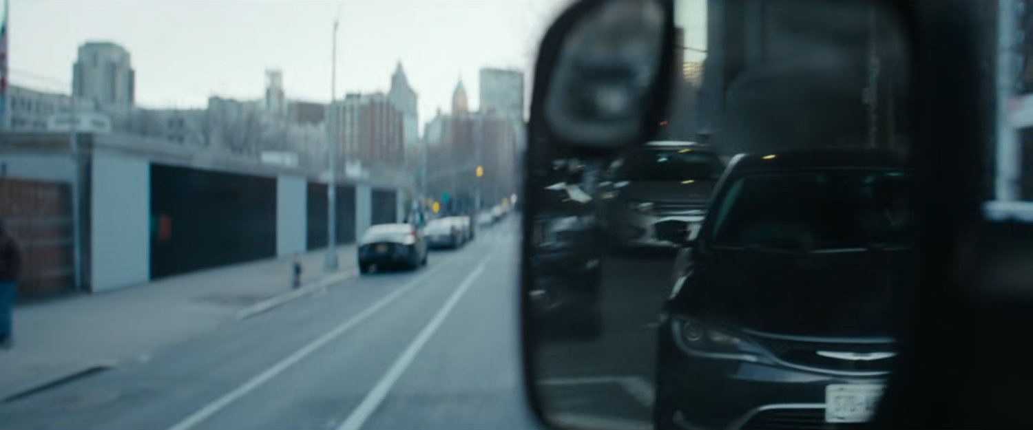 Cherry's POV in mirror of cars following his van.