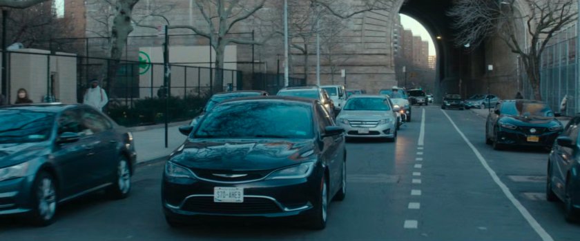 Cars and police motorcycle following van.