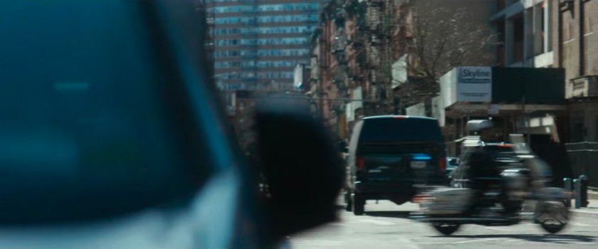 Motorcycle officer speeding past intersection.