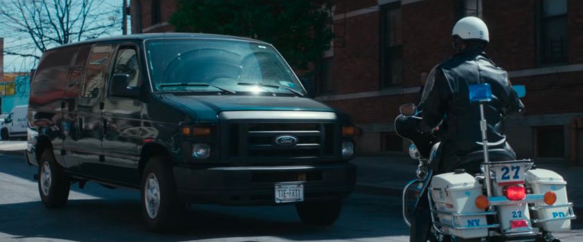 Motorcycle officer in front of van.