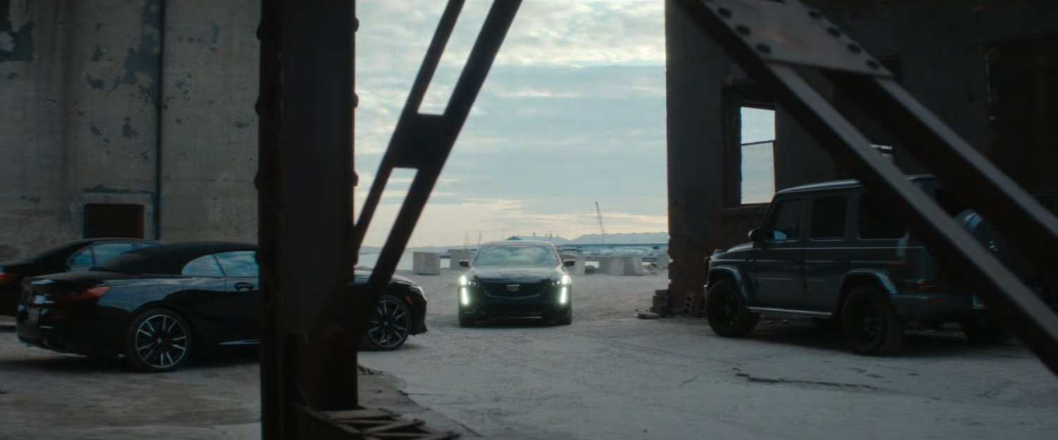 Car pulls up outside exterior of abandoned grain terminal.