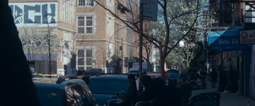 Interstitial: street and sidewalk, with graffiti building in background.