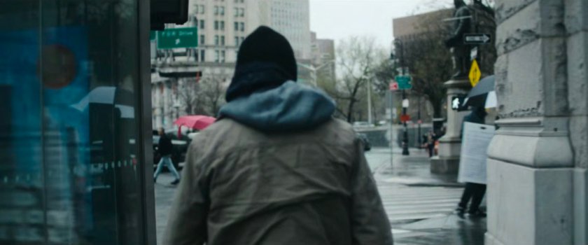 Interstitial: person in hoodie standing by intersection.