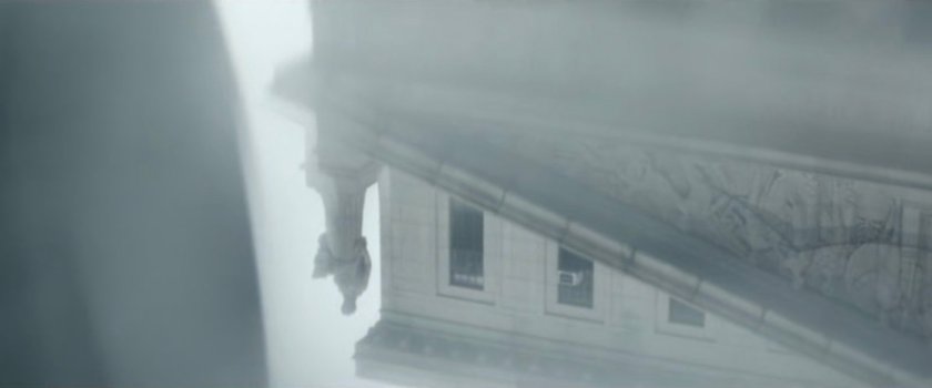 Interstitial: reflection of courthouse statue in puddle.