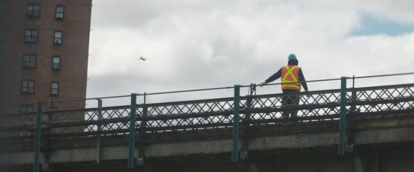 Interstitial: worker on train bridge.