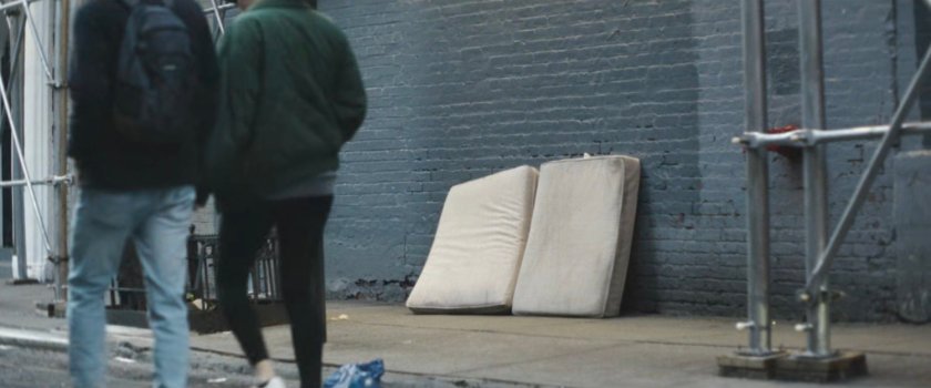 Interstitial: couple near sidewalk with mattresses.