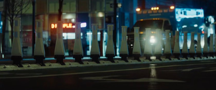 Interstitial: plastic pylons on street at night.