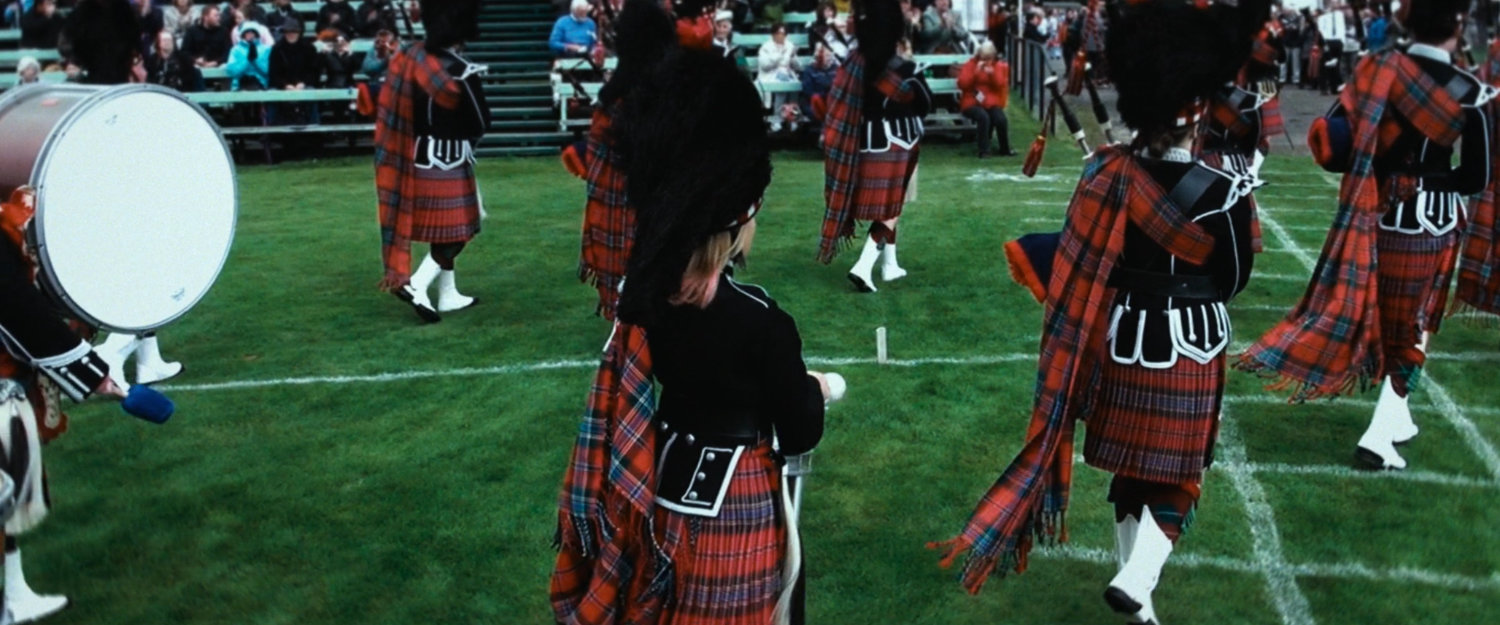 Interstitial: bagpipe band on field.