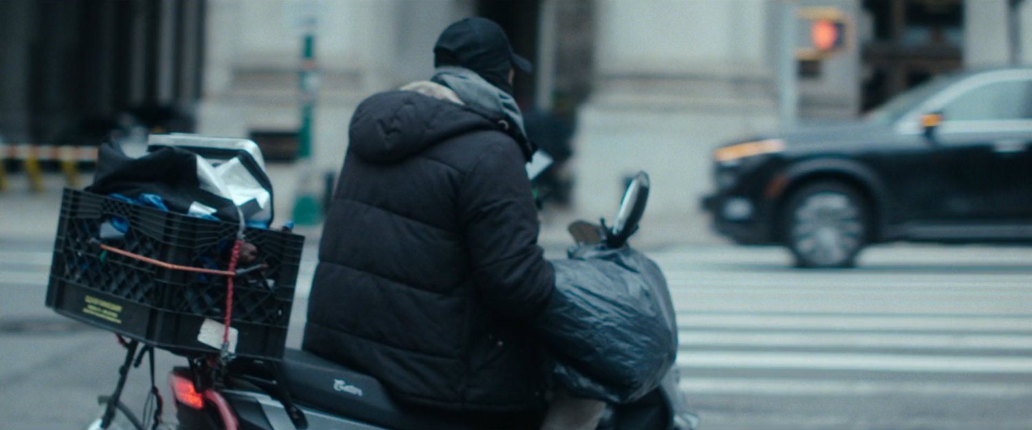 Interstitial: man on moped parked along street.