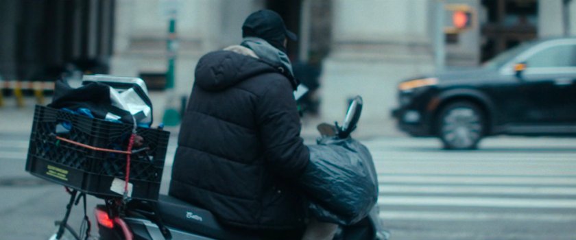 Interstitial: man on moped parked along street.
