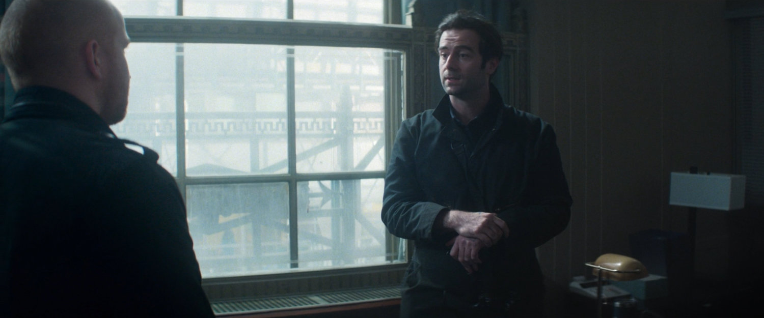 Devlin speaking with his fellow robber inside New York Mutual Bank.