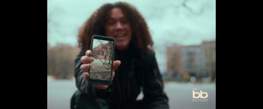 BB Report: man sitting on basketball court shows video on phone.