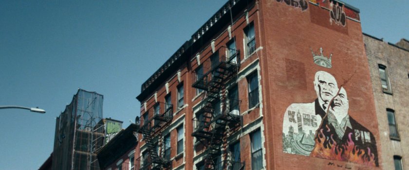 Interstitial: Kingpin mural on the side of brick apartment building.