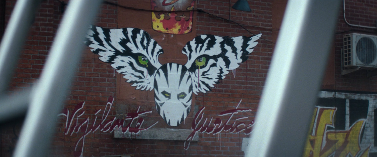 Interstitial: White Tiger 'vigilante justice' graffiti.