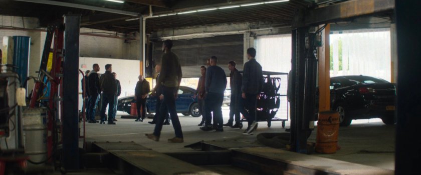 Plain clothes police officers meet with Fisk in police garage.