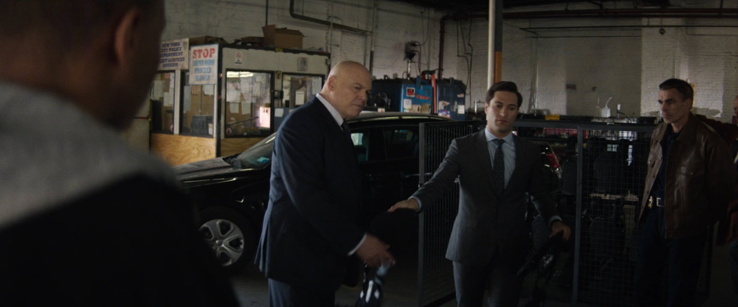 Plain clothes police officers meet with Fisk in police garage.
