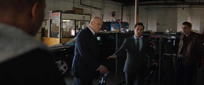 Plain clothes police officers meet with Fisk in police garage.