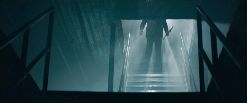 Fisk descending stairs into his "dungeon" with an ax.