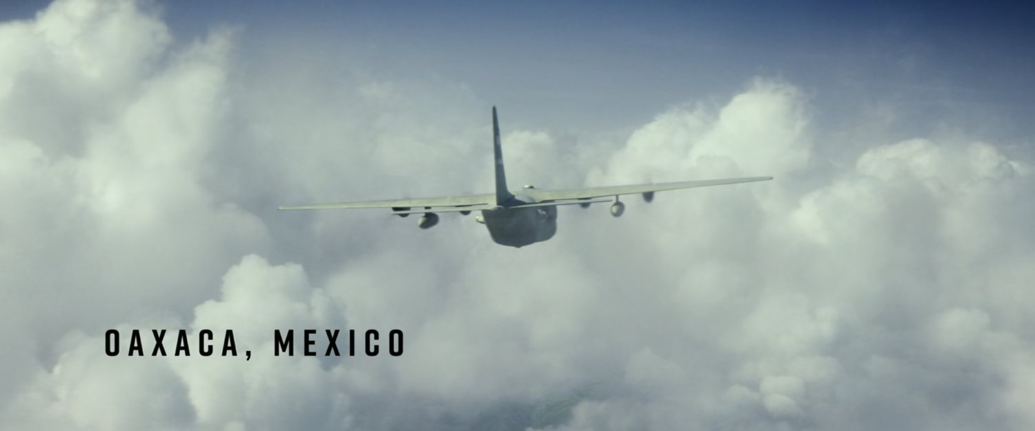 Cargo plane flying through clouds. Text: Oaxaca, Mexico.
