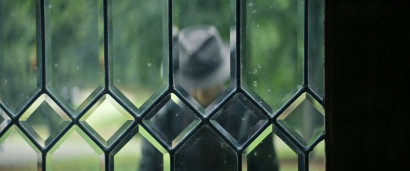 Samuel Sterns seen through glass on residential front door.