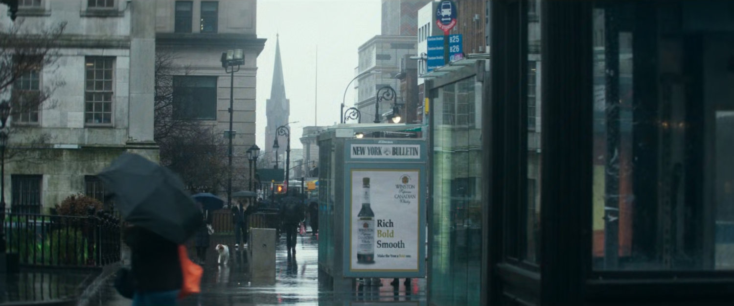 Interstitial: rainy sidewalk with church spire in distance.