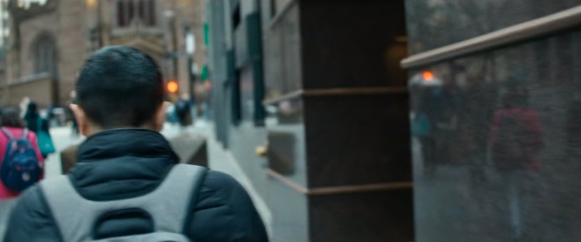 Interstitial: man with backpack walking along sidewalk.