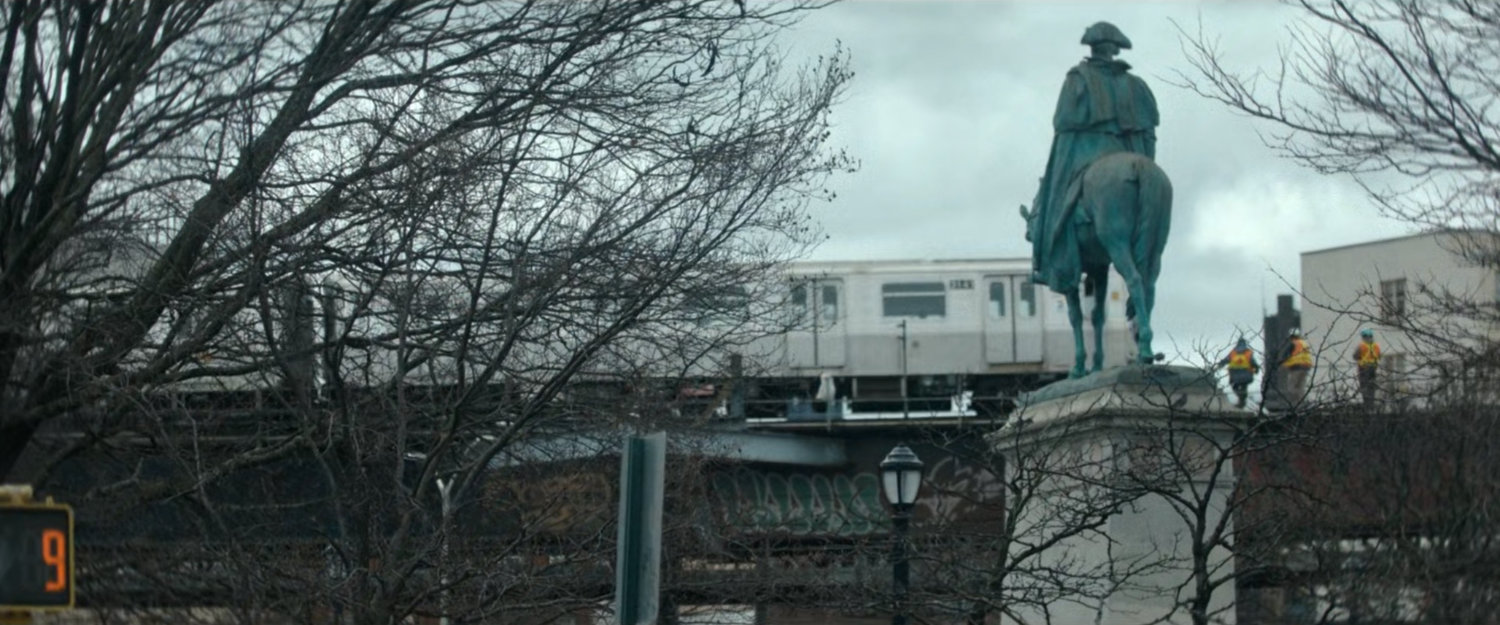 Interstitial: Train on elevated track with workers, statue of man on horse.