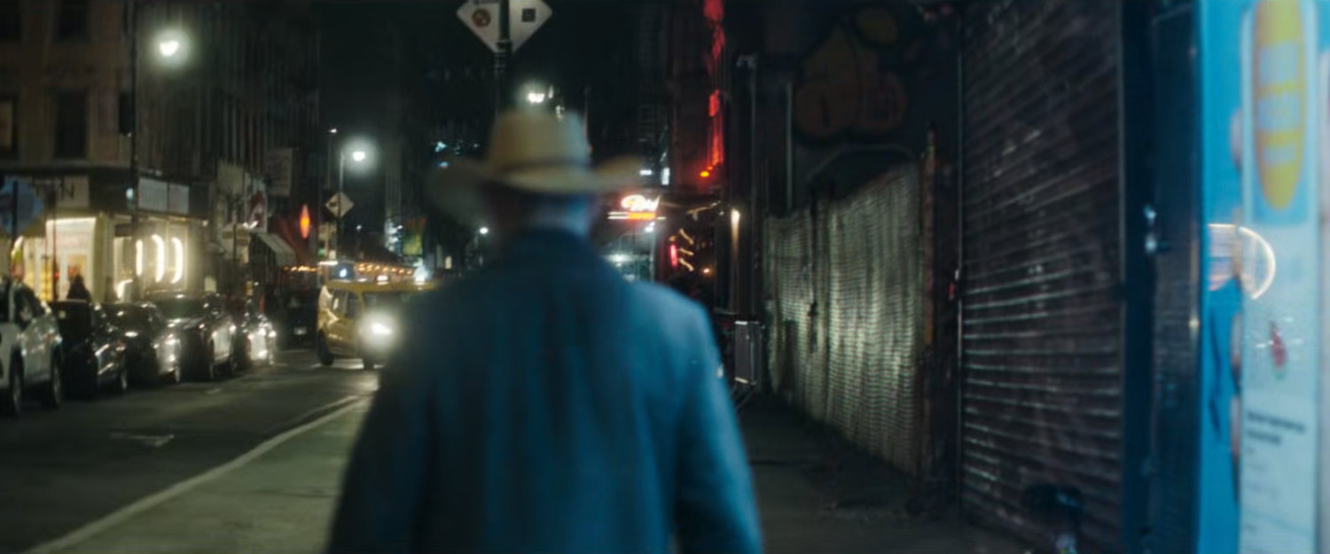 Interstitial: man walking along dark sidewalk.