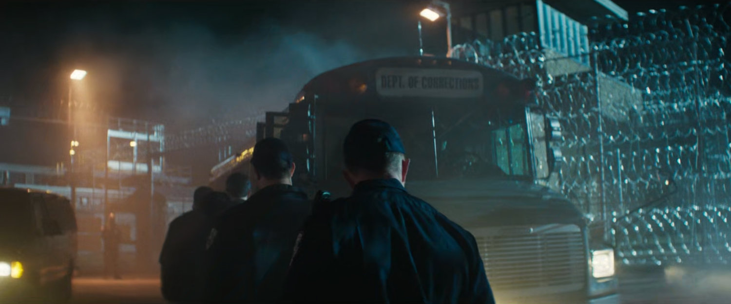 Guards board a bus outside Ryker's Island Penitentiary.