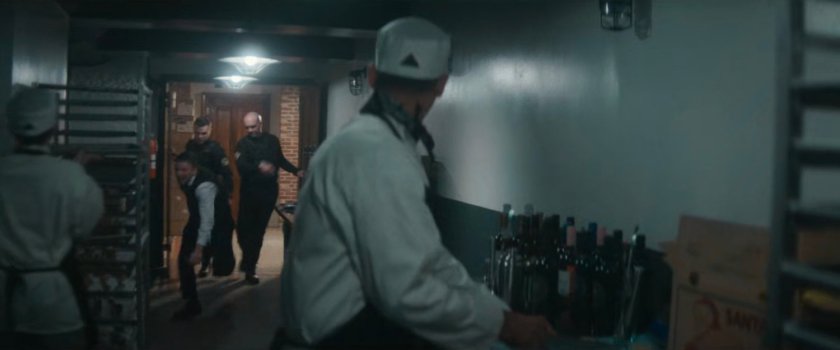 Police officers toss a reporter into the kitchen at the Black & White Ball.