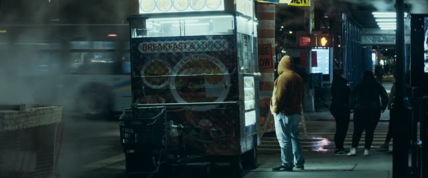 Interstitial: man outside food cart on sidewalk at night.