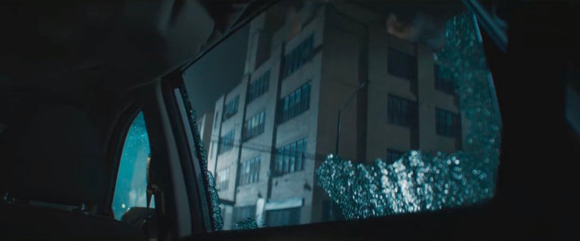 Matt's apartment building as seen through broken window.