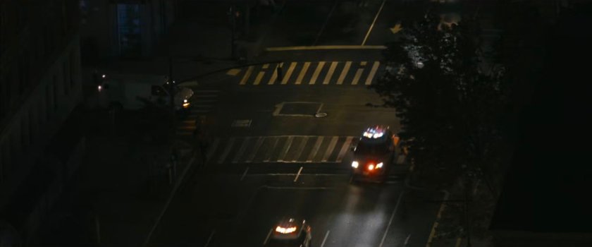 Interstitial: aerial view of police cars driving through intersection.