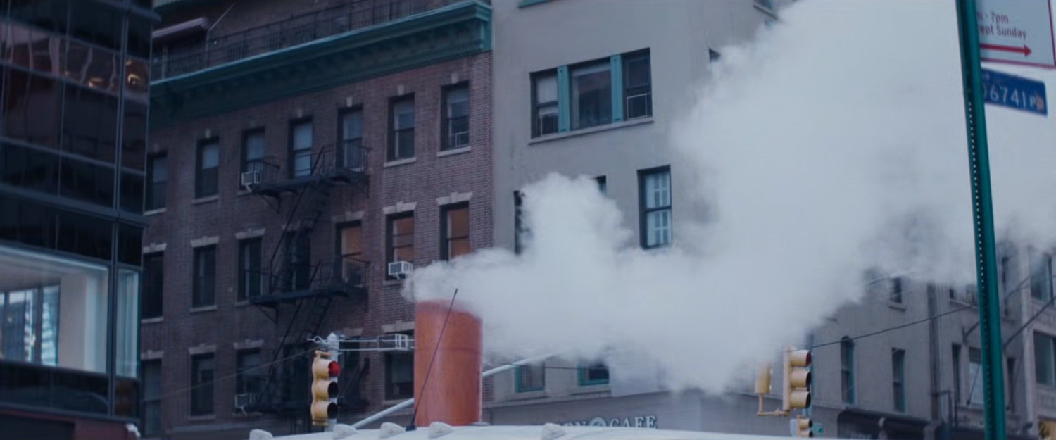 Interstitial: Steam riding from construction tube in front of buildings.