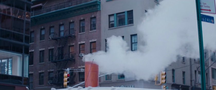 Interstitial: Steam riding from construction tube in front of buildings.