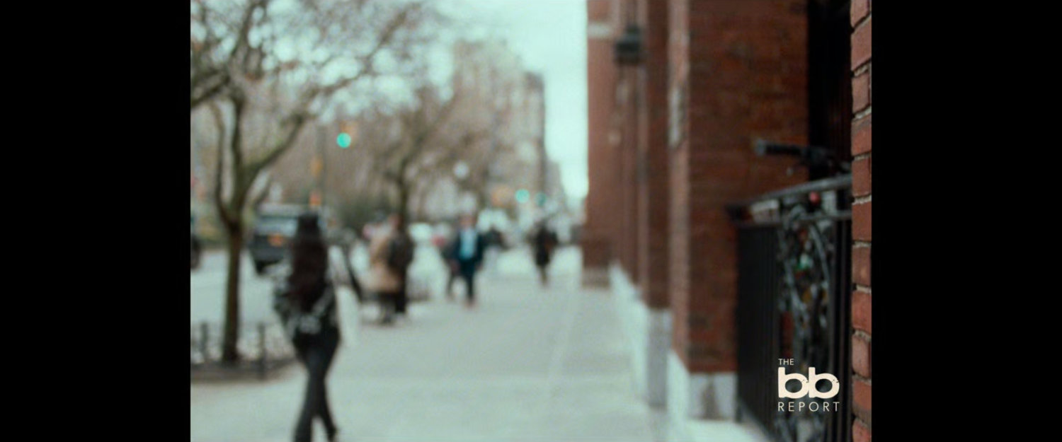 BB Report: pedestrians on sidewalk by brick building.