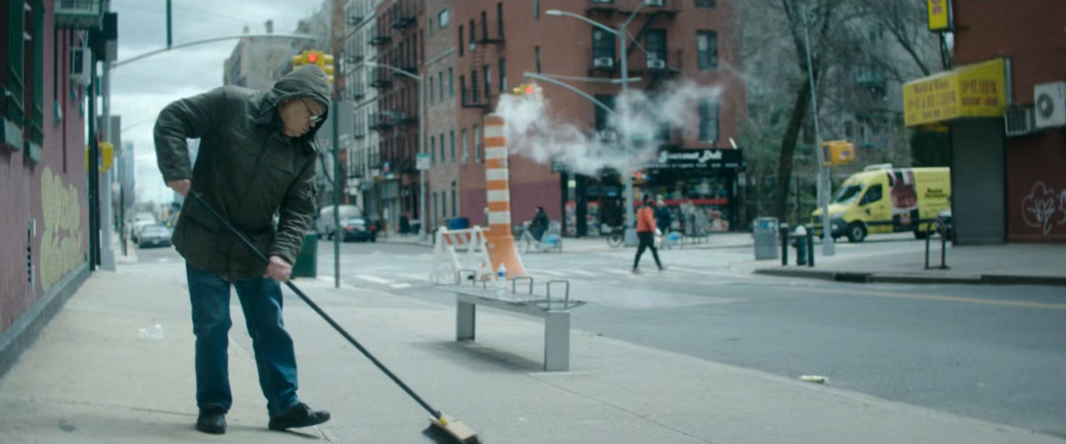 Interstitial: man sweeping sidewalk.