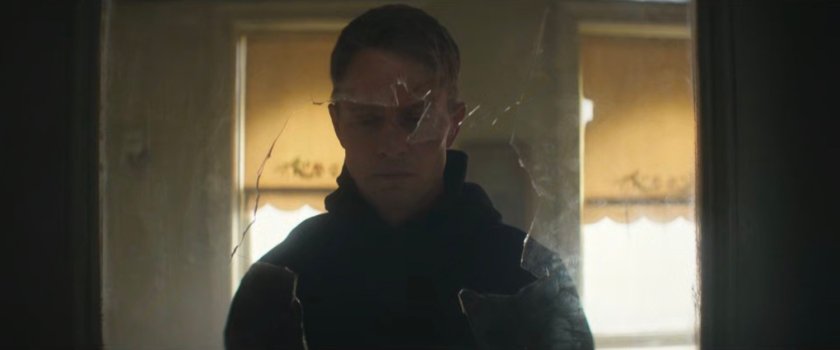 Dex looking through a broken window in an apartment.