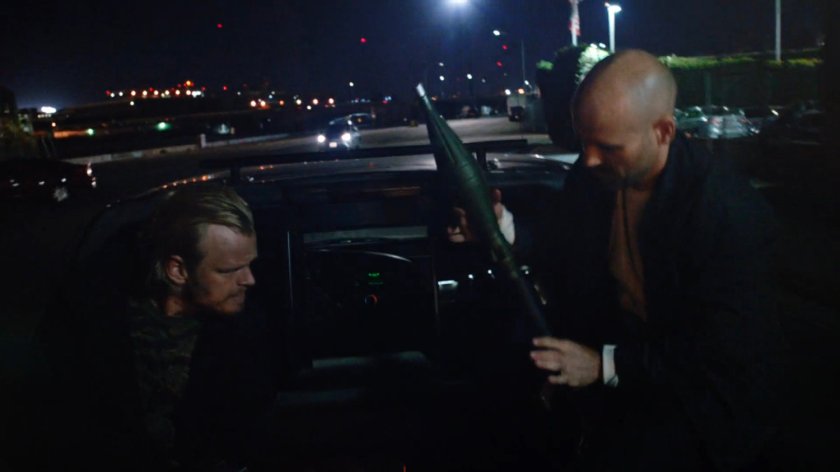 Two Watchdog members ready a rocket launcher in the back of a pickup truck.