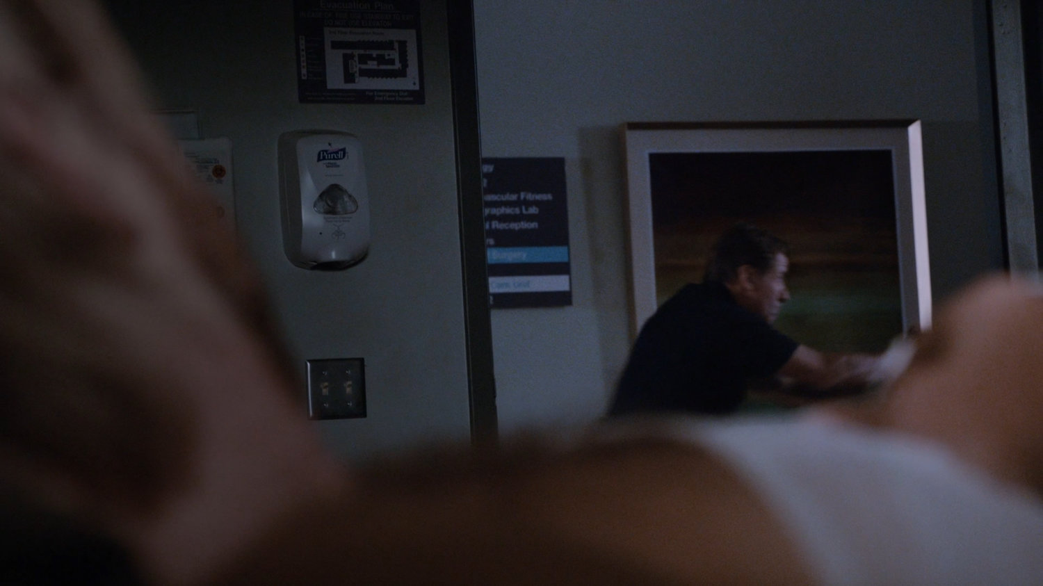 Hospital orderly in hall outside room.