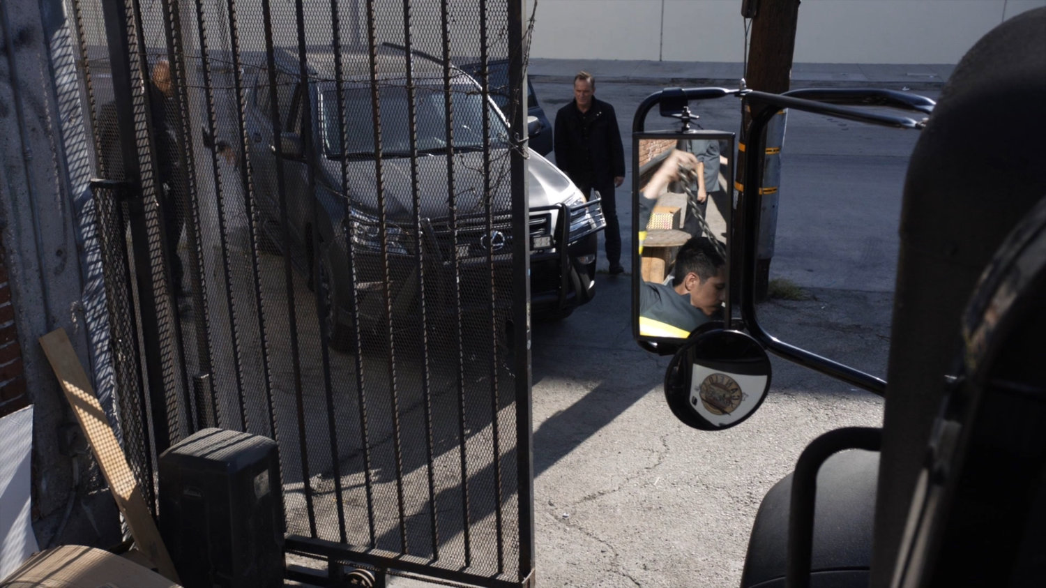 Coulson an Mack outside a fence at a warehouse.